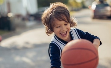 Little boy playing basketball after children's dentistry appointment