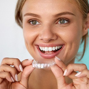 A woman using a take-home teeth whitening tray