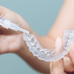 A man uses teeth whitening tools