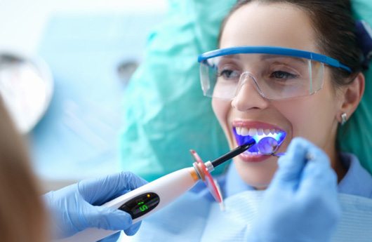 A dentist performing dental bonding on a patient