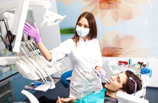A dentist performing an exam on a patient.