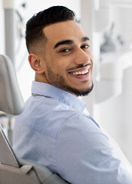 Man smiling while relaxing in dental chair