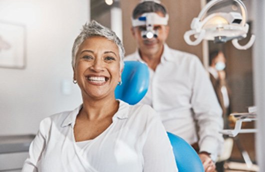 Woman in white shirt smiling before dental appointment