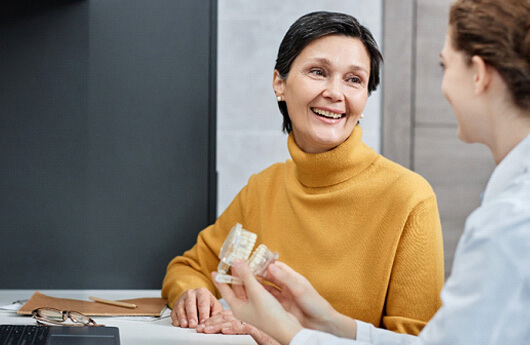 Woman talking to a dentist about dentures