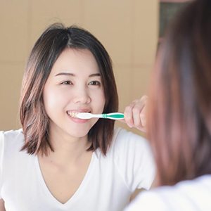 woman brushing her teeth 