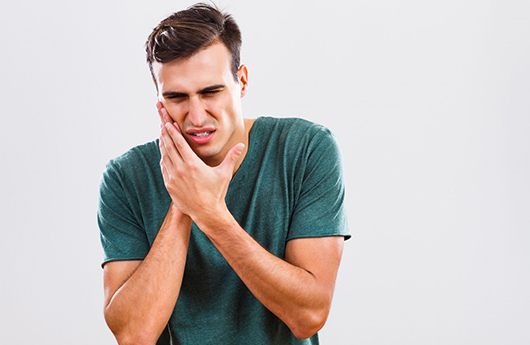 young man with toothache who needs emergency dentist in Lebanon