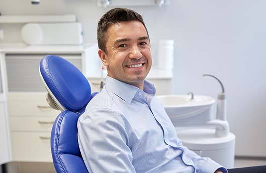 Man with a toothache in Lebanon smiling at a dental office