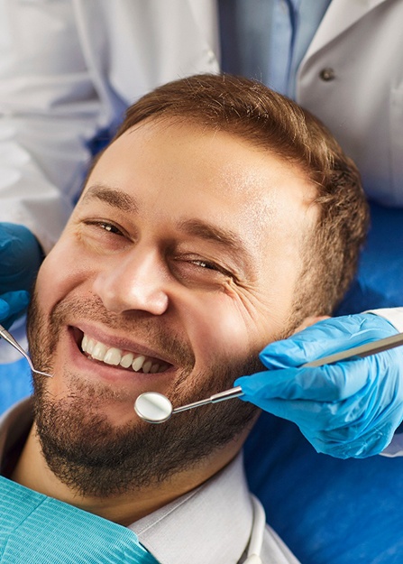 A man smiling at a dental checkup