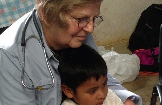 Dental team member holding child on mission trip