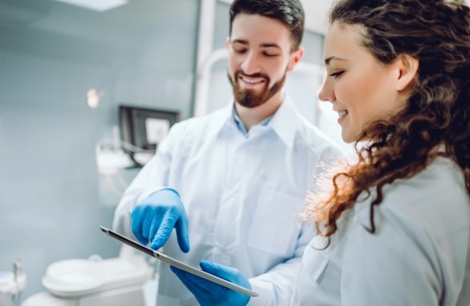 Dentist and patient looking at tablet computer