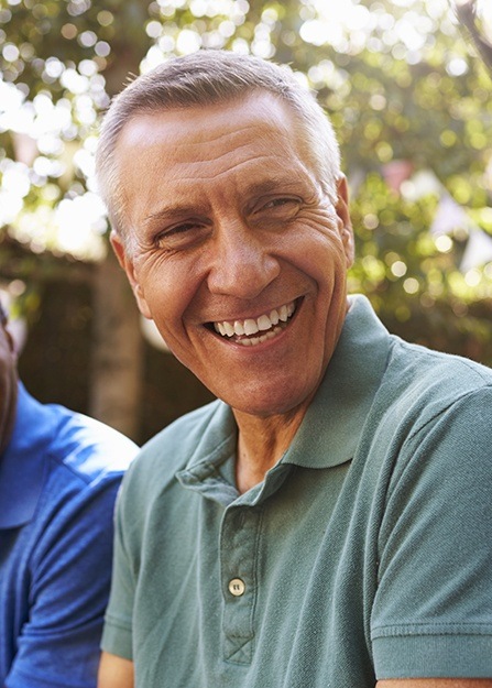 Man with healthy smile thanks to dental insurance covered dentistry care