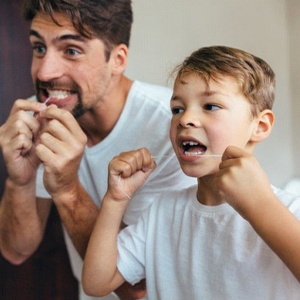 father and son flossing their teeth