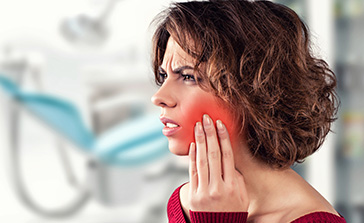 Woman in need of T M J therapy holding jaw in pain