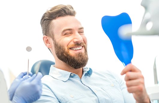 Man admires his teeth after smile makeover in Lebanon