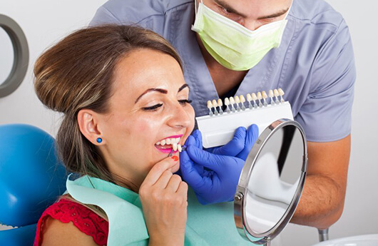 woman in red shirt trying on veneers 