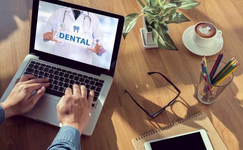 Man reviewing dental plan on laptop