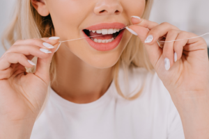 a close-up of a patient flossing their teeth