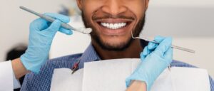 Close-up of smiling man being treated at dentist’s office.